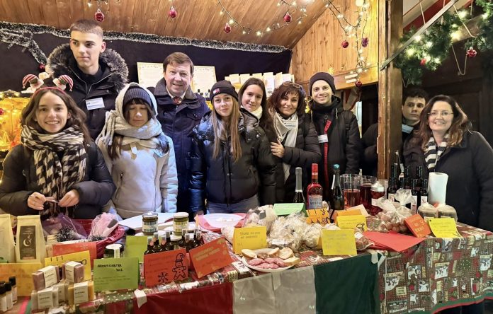 Jürgen Heckel mit Kindern in einer Weihnachtsmarktbude